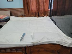 a bed with white sheets on it in a room at The Fortune Mango in Jajpur Road