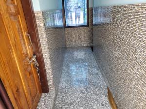 a bathroom with a walk in shower with a door at The Fortune Mango in Jajpur Road