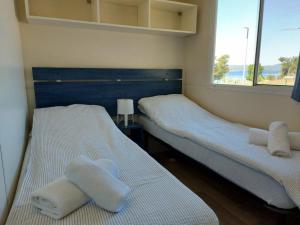 two beds in a small room with towels on them at Regina Mobile Home 3 Bedrooms, 100m to Beach, Family Friendly in Sveti Filip i Jakov