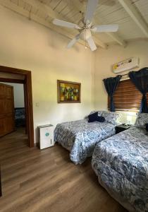 a room with two beds and a ceiling fan at Casa Selva Escondida in Los Altos de Cerro Azul