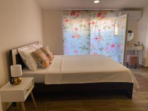 a bedroom with a large bed with a floral curtain at City Suites Budva in Budva