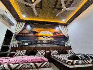 two beds in a room with a mural on the wall at Hotel Manasvi in Khātu