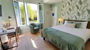 ein Schlafzimmer mit einem Bett, einem Schreibtisch und einem Stuhl in der Unterkunft Logis Hotel Le Cerf in Briare