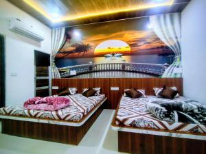 two beds in a room with a painting on the wall at Hotel Manasvi in Khātu