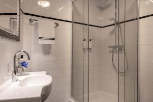a white bathroom with a shower and a sink at Logementen Dokkum in Dokkum +9 photos