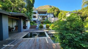 a house with a wooden deck with a pond at The Mansion Lodge in Hartbeespoort