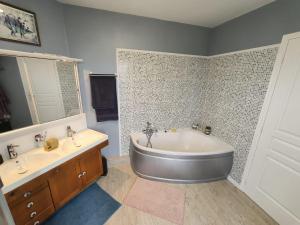 a bathroom with a large tub and two sinks at Chambre, comme au cinéma in Givet