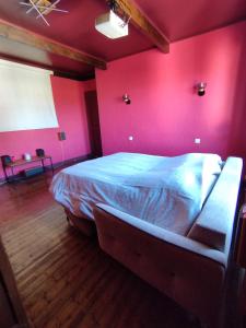 a bedroom with a large bed in a red wall at Chambre, comme au cinéma in Givet