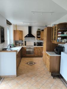 a large kitchen with wooden cabinets and a stove at Chambre, comme au cinéma in Givet