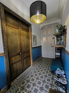 a hallway with a wooden door and a blue wall at Chambre, comme au cinéma in Givet