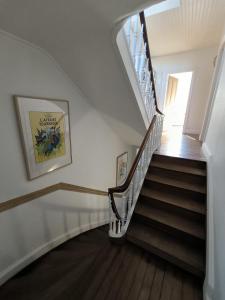 a staircase in a home with white walls and wooden floors at Chambre, comme au cinéma in Givet