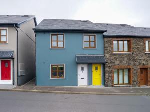 a blue house with colorful doors on a street at Central Dingle Stay in Dingle