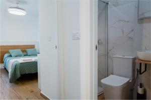 a bathroom with a toilet and a sink and a bed at El Rinconcito de mi Alma in Caravaca de la Cruz