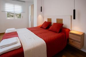 a bedroom with a red and white bed with a window at El Rinconcito de mi Alma in Caravaca de la Cruz