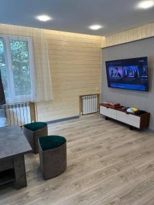 a large living room with a flat screen tv on the wall at Bellissimo Garden Villa in Tsaghkadzor