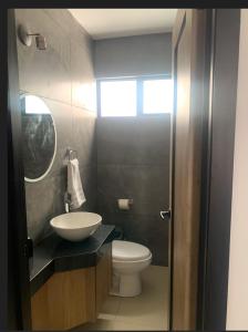 a bathroom with a white toilet and a sink at Complejo Las Flores in Durango