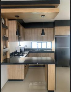 a kitchen with wooden cabinets and a black counter top at Complejo Las Flores in Durango