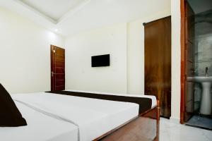 a bedroom with a white bed and a sink at Hotel O Classic in in Kharar