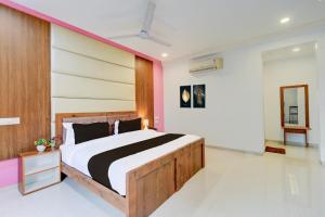 a bedroom with a large bed with a wooden headboard at Super Hotel O SRI NIRVANA PLAZA in Gachibowli