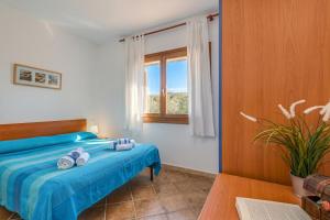 a bedroom with a bed with blue sheets and a window at Le Dimore di Nettuno in Olbia