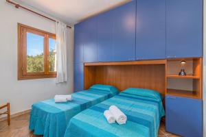 two beds in a room with blue walls at Le Dimore di Nettuno in Olbia +111 photos