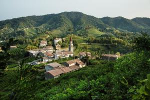 a small village on a hill with a church at B&B Gastaldo di Rolle in Cison di Valmarino
