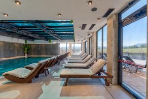 a pool with lounge chairs and a swimming pool at Villa Di Montagna wellness & spa in Zlatibor