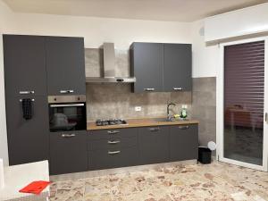 a kitchen with gray cabinets and a sink at Dayana House in Gallipoli