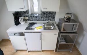 a small kitchen with a sink and a microwave at Luv Lee Duhnen 09 in Cuxhaven
