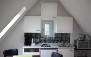 a kitchen with white cabinets and a sink at Luv Lee Duhnen 09 in Cuxhaven