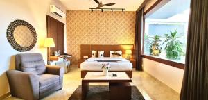 a bedroom with a bed and a chair and a table at Villa Escape In in Kuilapayam