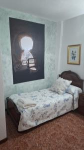 a bedroom with a bed with a painting on the wall at Pensiòn ISASA in Arnedo