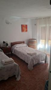 a bedroom with two beds and a wine barrel at Pensiòn ISASA in Arnedo