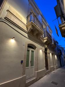 a white building with a balcony and a door at Romantico bilocale ad Ortigia in Syracuse