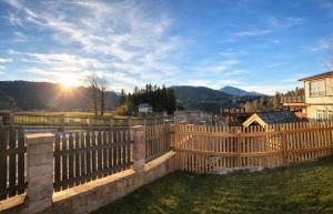 a wooden fence with the sun in the background at Casa Roberto, Apartment 1 in Mariazell +5 photos