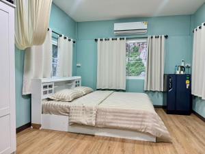 a bedroom with a bed and a blue wall at นพรัตน์การ์เด้นฮิลล์ in Uthai Thani