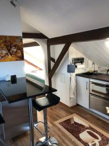 a kitchen with a counter and a stool in a room at Studio Banniza in Wolfratshausen