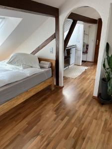 a bedroom with a bed and a wooden floor at Studio Banniza in Wolfratshausen