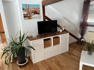 a white cabinet with a television on top of it at Studio Banniza in Wolfratshausen