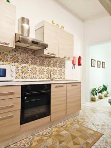 a kitchen with wooden cabinets and a stove at Dar Marija in Valletta