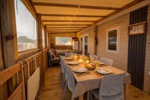 a dining room with a table and chairs on a porch at Mobilhome La Pause Océane - La Plage in Mimizan-Plage