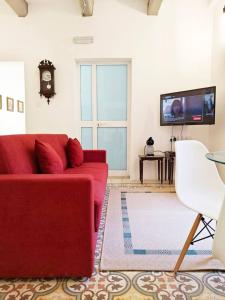 a living room with a red couch and a tv at Dar Marija in Valletta