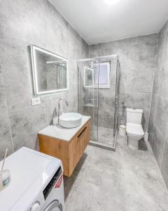 a bathroom with a sink and a shower and a toilet at Modern Air Conditioned 2BR in Heart of Shkodër in Shkodër +12 photos