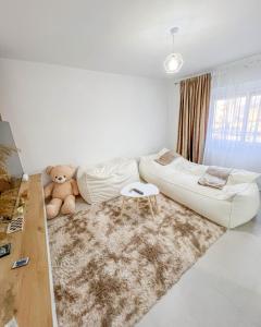 a white living room with a couch and a teddy bear at Modern Air Conditioned 2BR in Heart of Shkodër in Shkodër