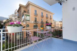 un balcone con tavoli e sedie di fronte a un edificio di Vanna Home a Sorrento