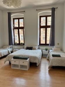 a bedroom with two beds and two windows at Apartament przy Kościele in Świdnica +9 photos