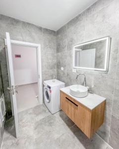 a bathroom with a washing machine and a sink at Modern Air Conditioned 2BR in Heart of Shkodër in Shkodër