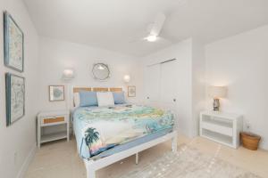 a white bedroom with a bed and two night stands at Mariner Pointe #521 in Sanibel