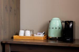 a coffee maker and cups on a wooden shelf at Logementen Dokkum in Dokkum