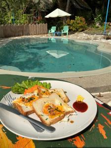 a plate of food on a table in front of a swimming pool at Elephant garden2 in Trat